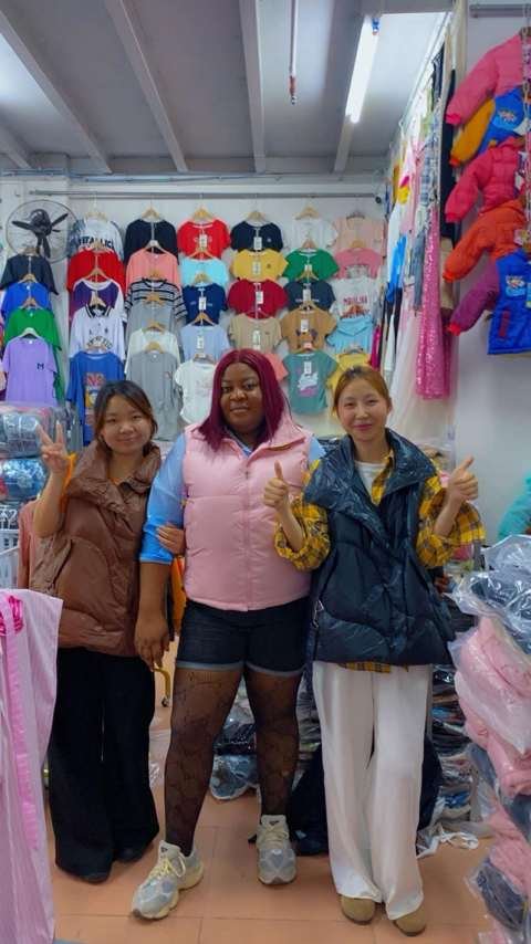 Queen Nkem with her Chinese suppliers in a clothing shop