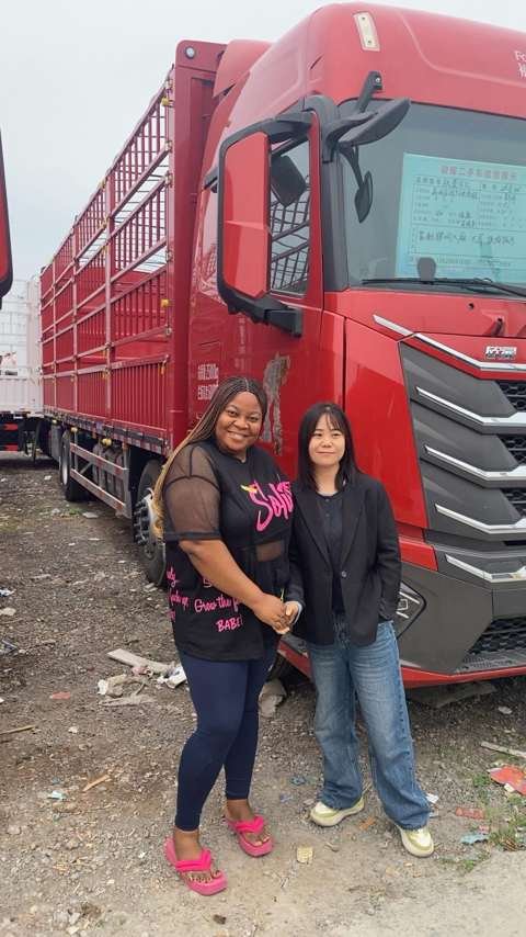 Queen Nkem with a Chinese logistics partner in front of a cargo truck