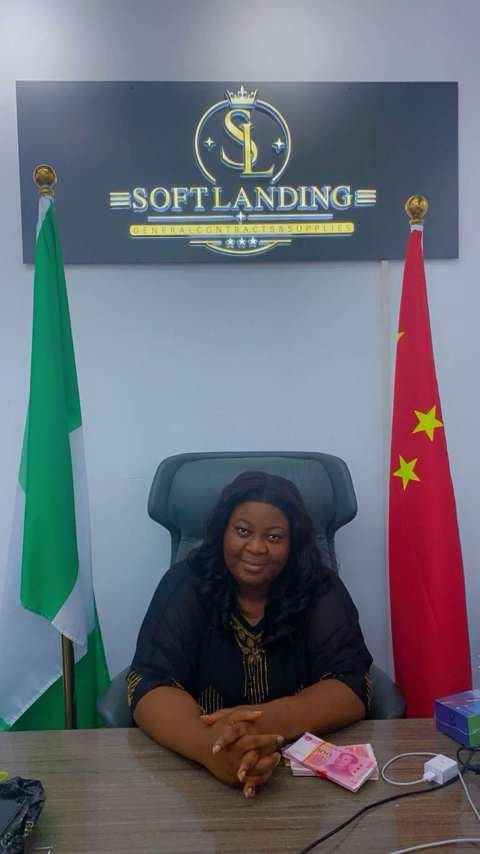Queen Nkem at the Softlanding office desk with Nigerian and Chinese flags